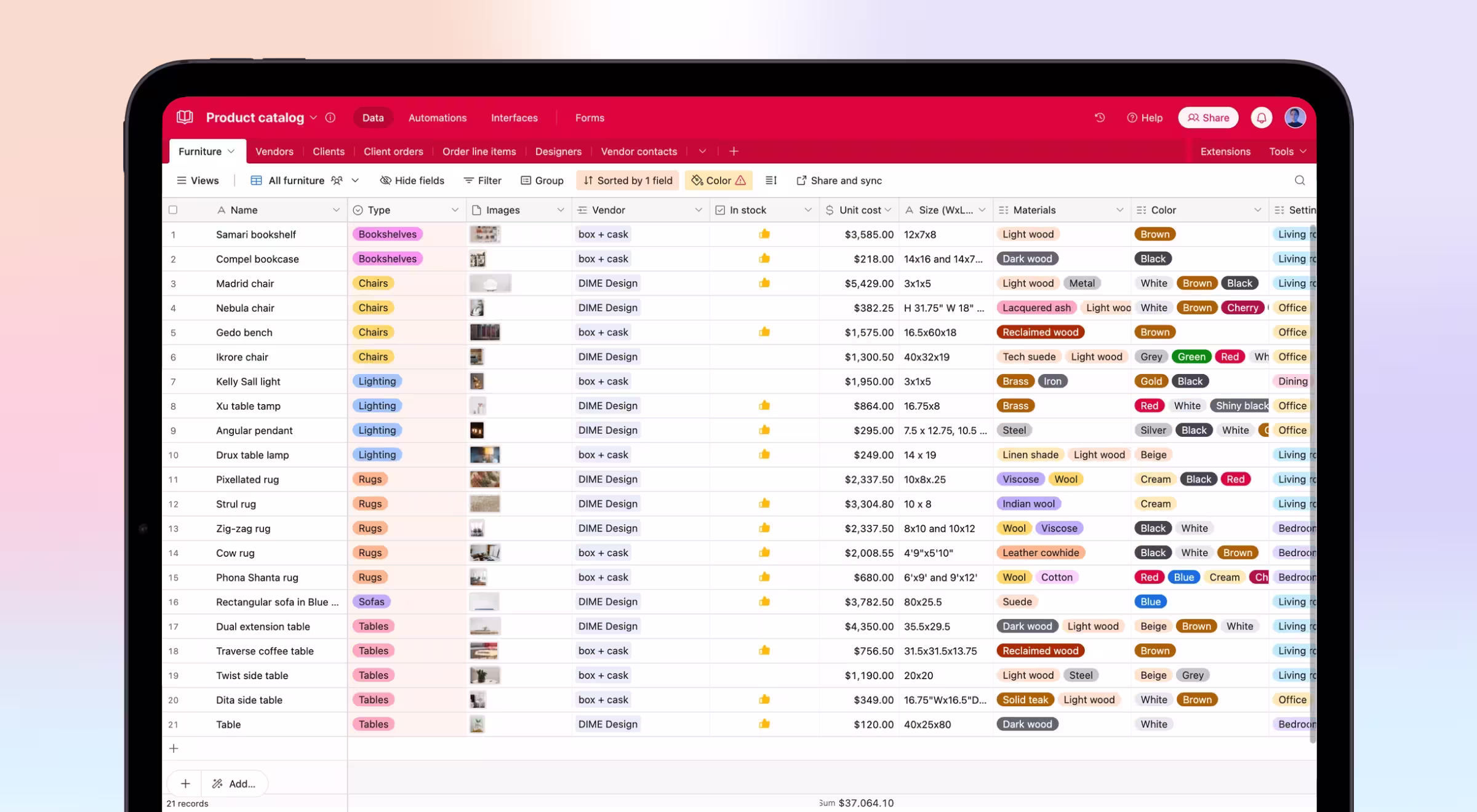 Tablet screen displaying a colorful Airtable-style product catalog titled 'Product catalog.' The table includes rows of furniture items with columns for name, type, images, vendor, stock status, unit cost, size, materials, colors, and settings. Each entry is tagged with color-coded labels for categories like 'Chairs,' 'Lighting,' 'Rugs,' and more. Thumbs-up icons indicate in-stock items.