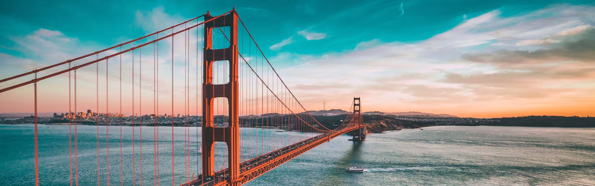 Bridge at sunset with city skyline and bay view.