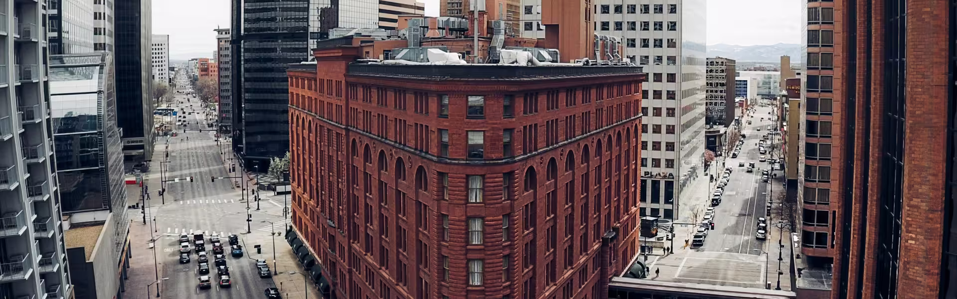 Downtown Denver cityscape featuring historic red brick buildings and modern skyscrapers along 17th Street