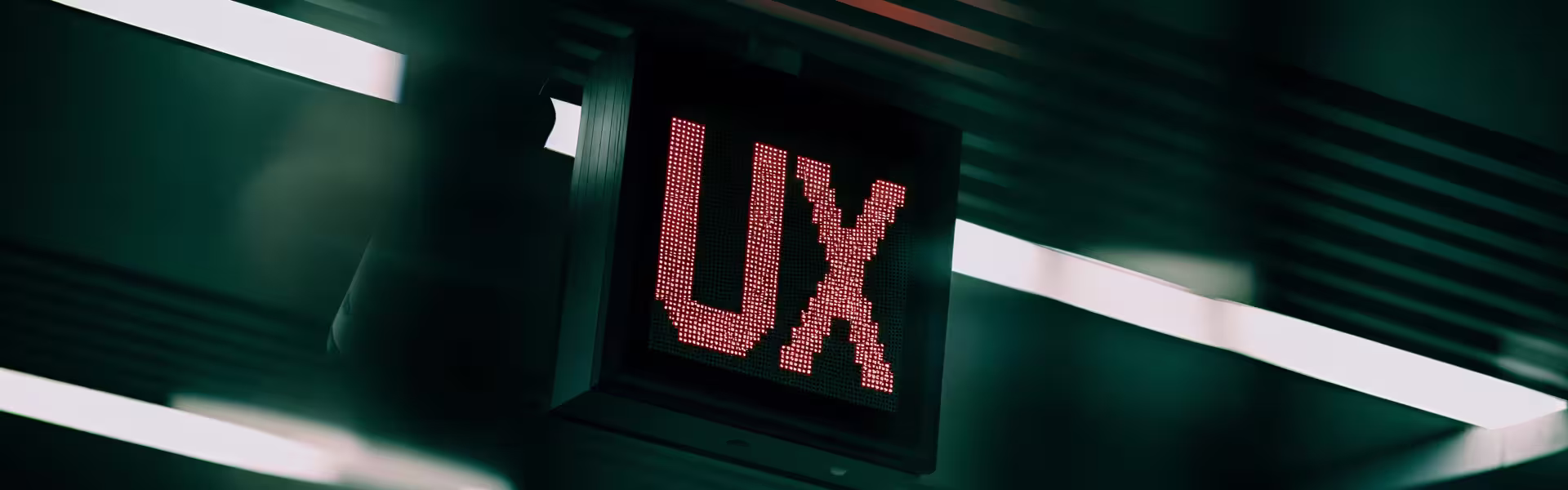Red LED digital sign displaying ‘UX’ in a modern environment — symbolic image representing user experience design and digital product innovation by Lazarev.agency