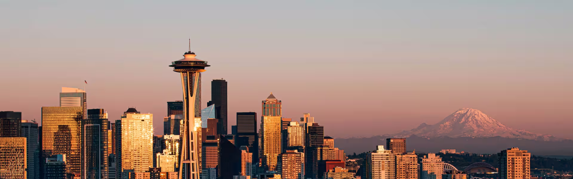 Seattle city skyline at sunset with Space Needle and Mount Rainier in the background