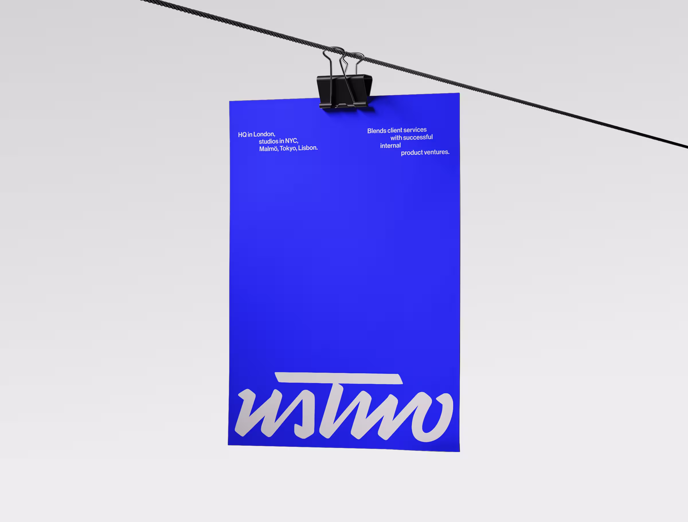 Bright blue poster featuring the ustwo logo at the bottom, hanging from a clipped wire against a minimal light background