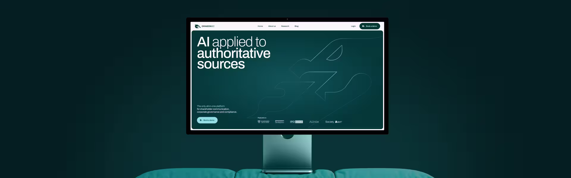 Desktop monitor displaying the DRAGONGC website homepage with the headline ‘AI applied to authoritative sources,’ set against a dark teal gradient background