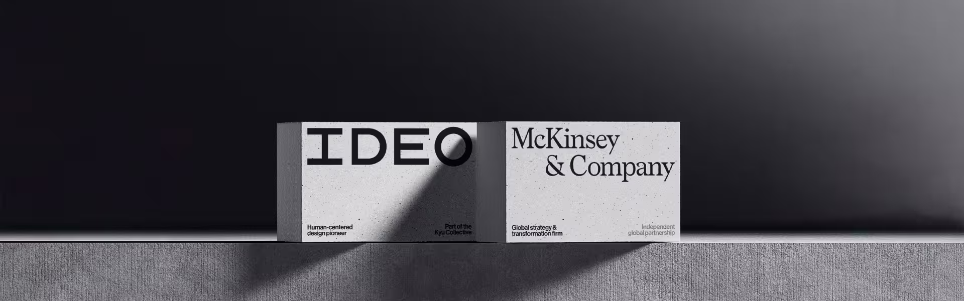 Minimalist concrete blocks displaying the IDEO logo next to McKinsey & Company branding, symbolizing the integration of human-centered design and global business strategy
