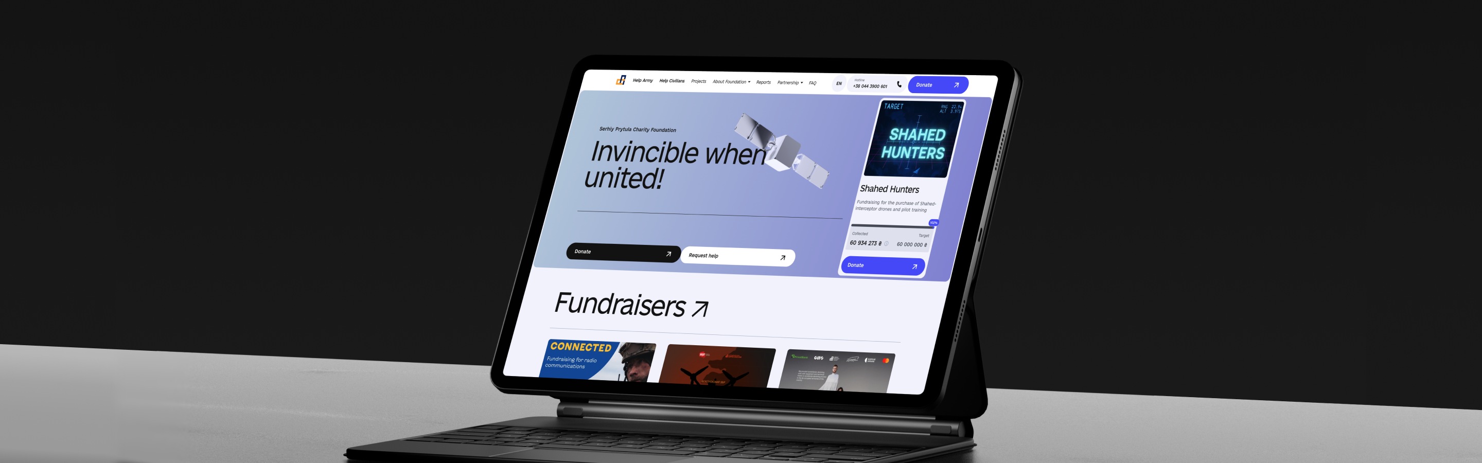 A tablet displaying a charity website featuring a fundraising campaign titled "Invincible when united!" with a donation button.