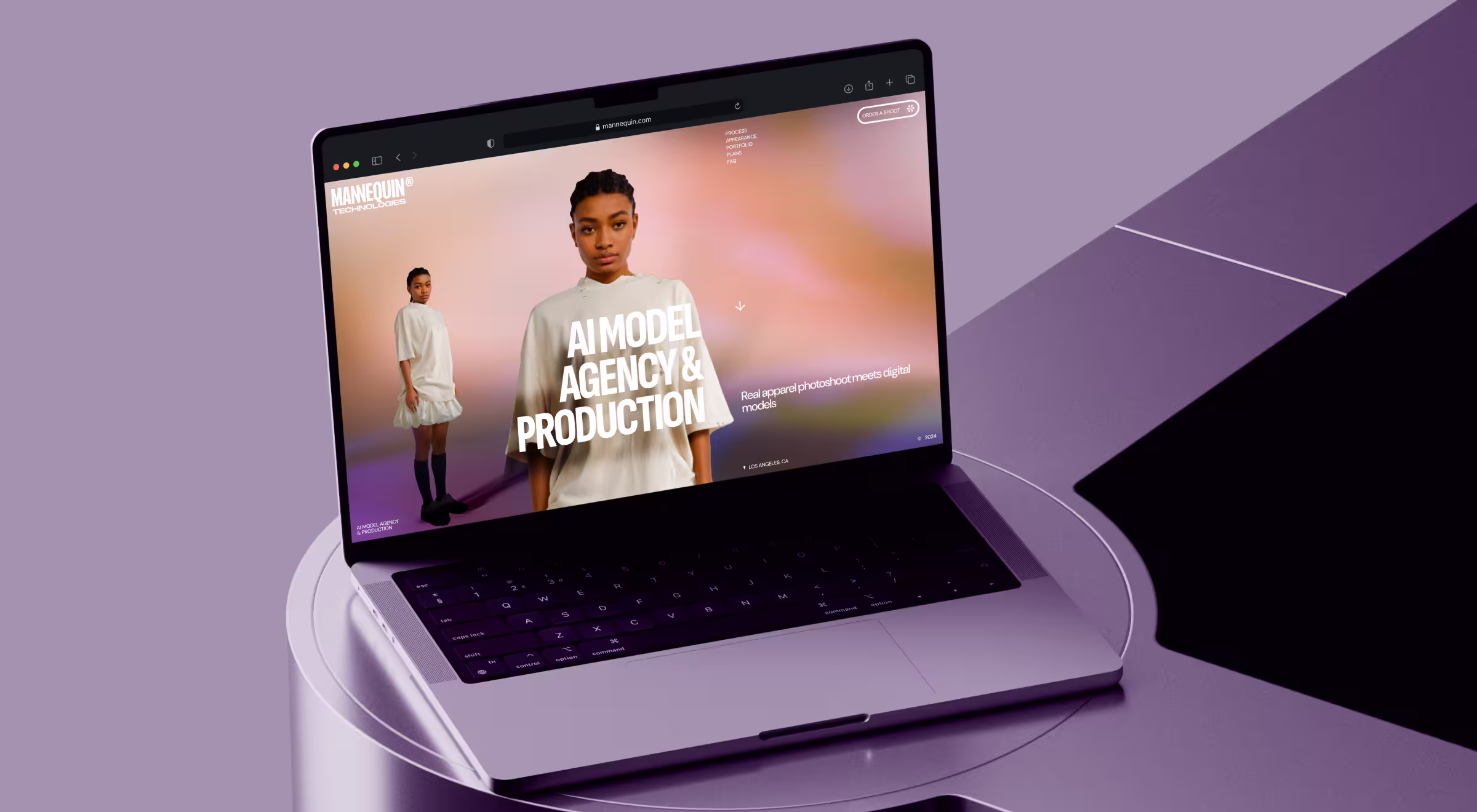 Laptop displayed on a minimal, soft-purple studio set showing the Mannequin Technologies website