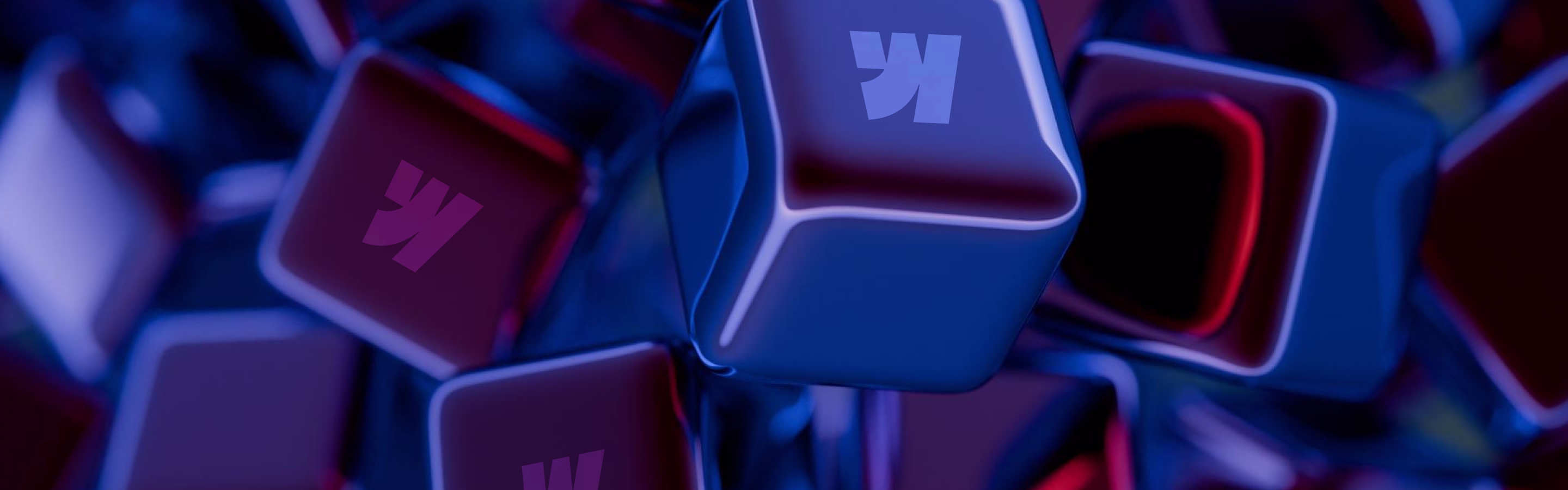 Abstract close-up of glossy, colorful cubes with a stylized letter "K" embossed, set against a rich blue and red gradient background.