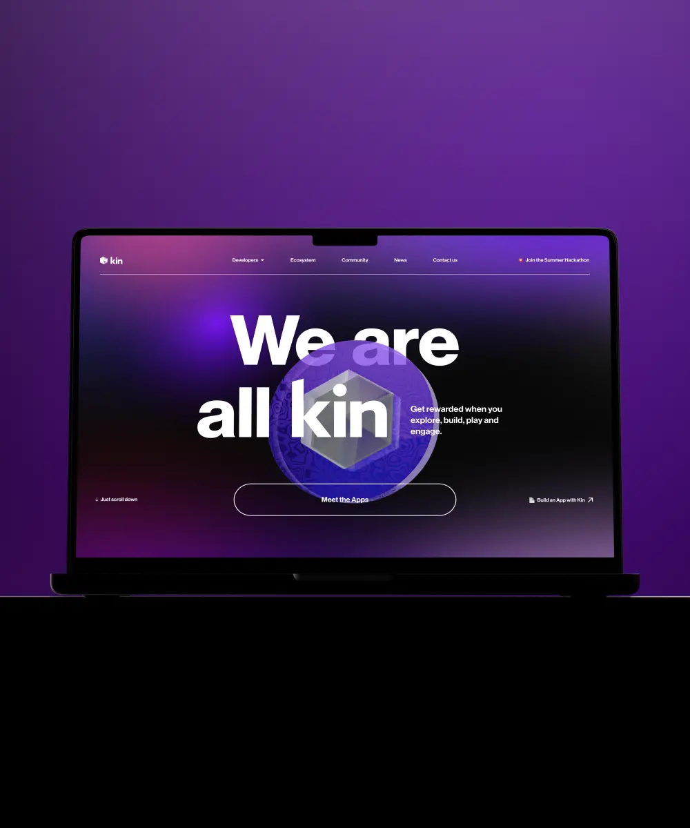 A laptop displays a vibrant purple webpage with "We are all kin" text, promoting community engagement and app development.