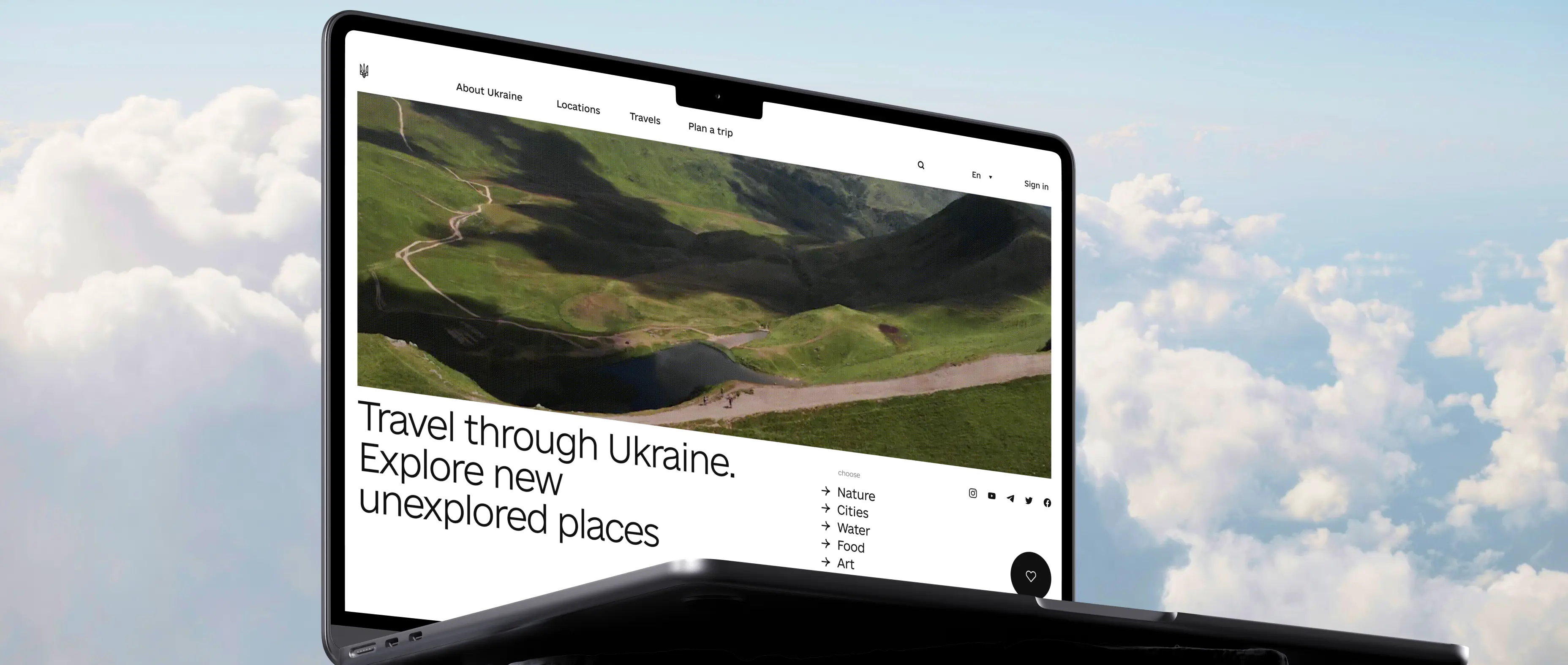 Close-up of a laptop displaying a tourism website for Ukraine, featuring a panoramic mountain landscape, destination categories, and trip-planning navigation, set against a backdrop of soft clouds to evoke travel, discovery, and exploration.