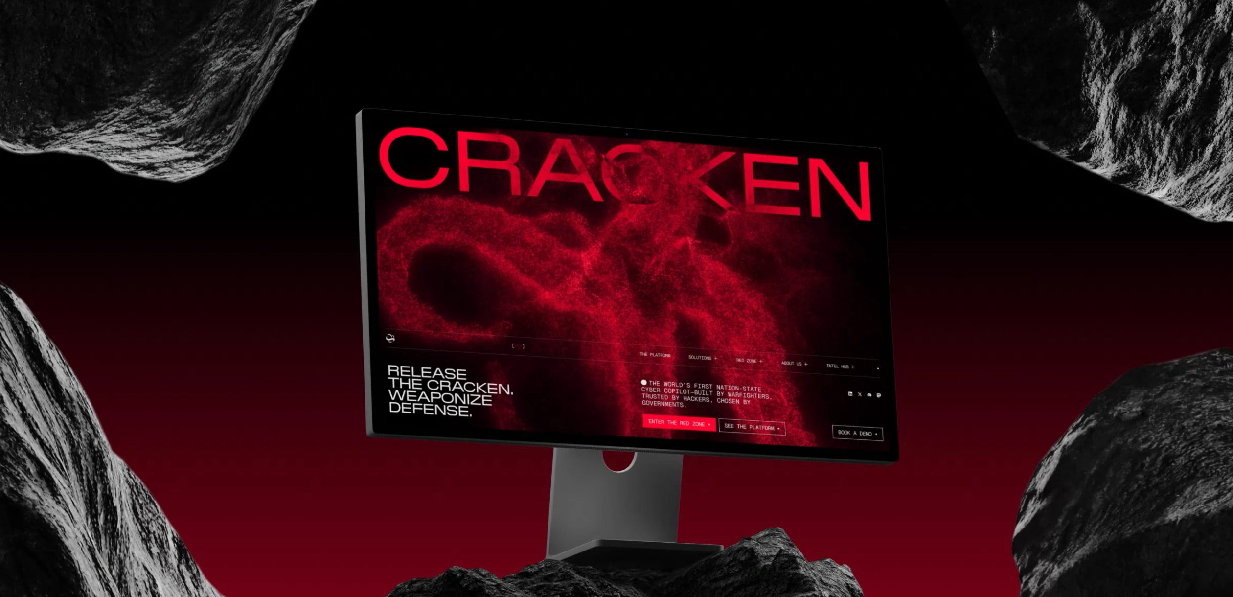 Cracken cybersecurity website hero displayed on a desktop monitor, using intense red visuals, dark rocky surroundings, and the headline “Release the Cracken. Weaponize defense.”