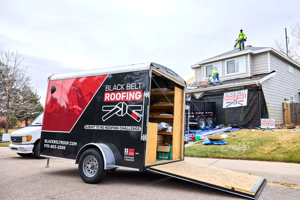 Black Belt Roofing trailer at a residential roof replacement project.