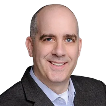 Smiling bald man wearing a dark suit jacket and light blue collared shirt.