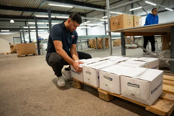 Tristo-medewerker voert logistiek werk uit en verplaatst dozen in een magazijn.