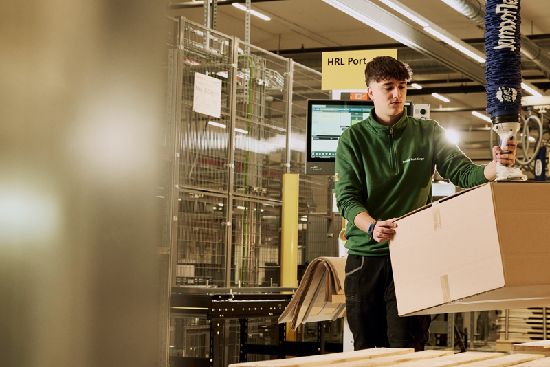 Mann in Logistikzentrum mit Paket / Fotoshooting on Location Logistik