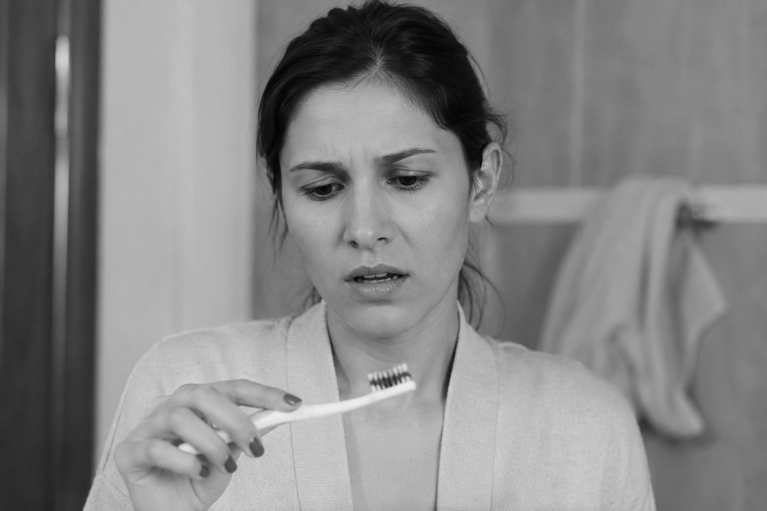 Woman looks at toothbrush and see blood