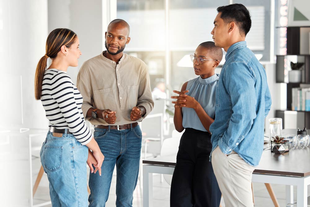 Diverse group of people having a discussion in an office setting, representing cultural perspectives on ADHD around the world.