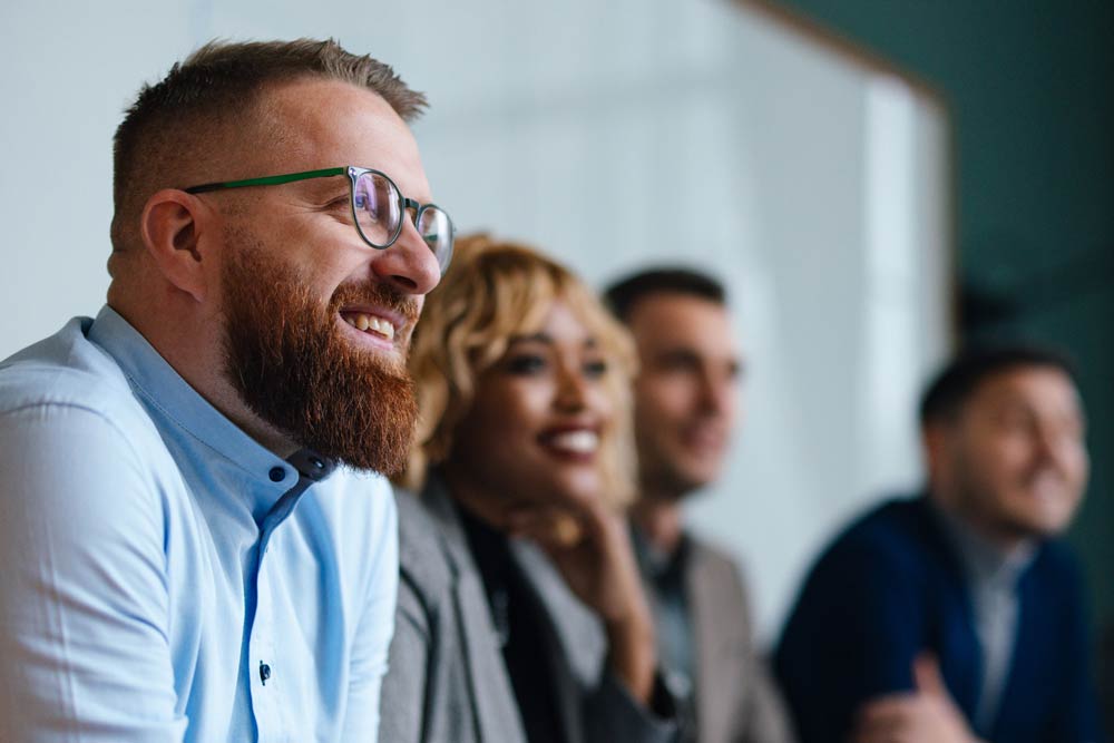 A diverse group of professionals smiling and engaged in discussion, representing balanced research perspectives on ADHD diagnosis and public understanding.