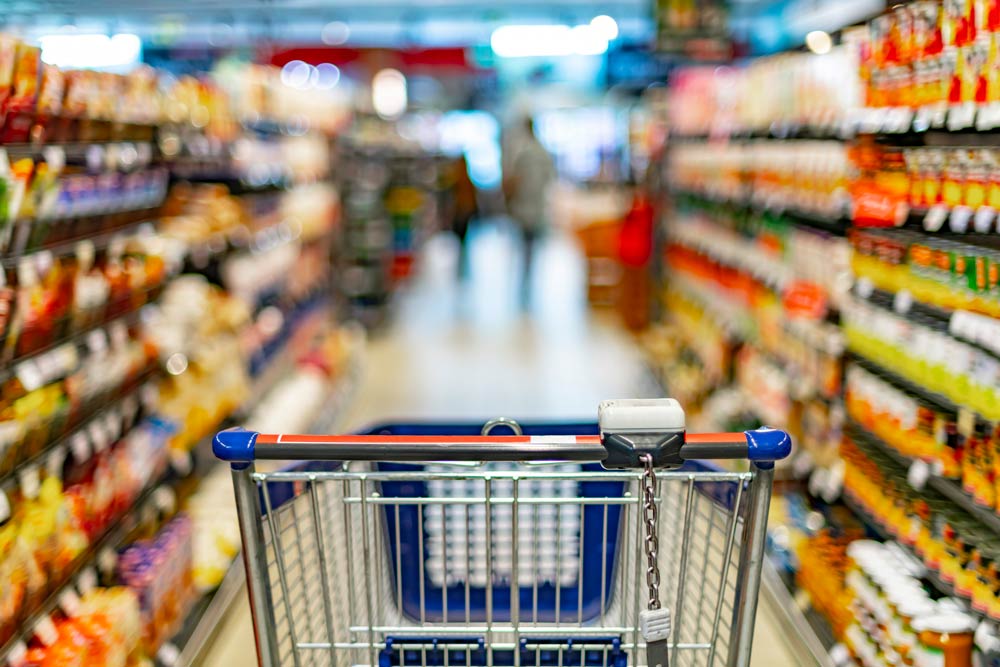 A grocery shopping cart in a brightly lit supermarket aisle, representing the importance of mindful food choices for managing ADHD symptoms and promoting better focus.