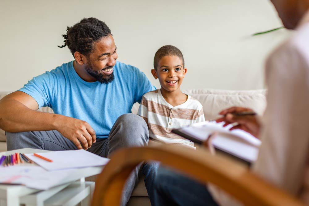 Therapist talking with a parent during a behavioural intervention session, representing parent-focused ADHD training and support strategies.