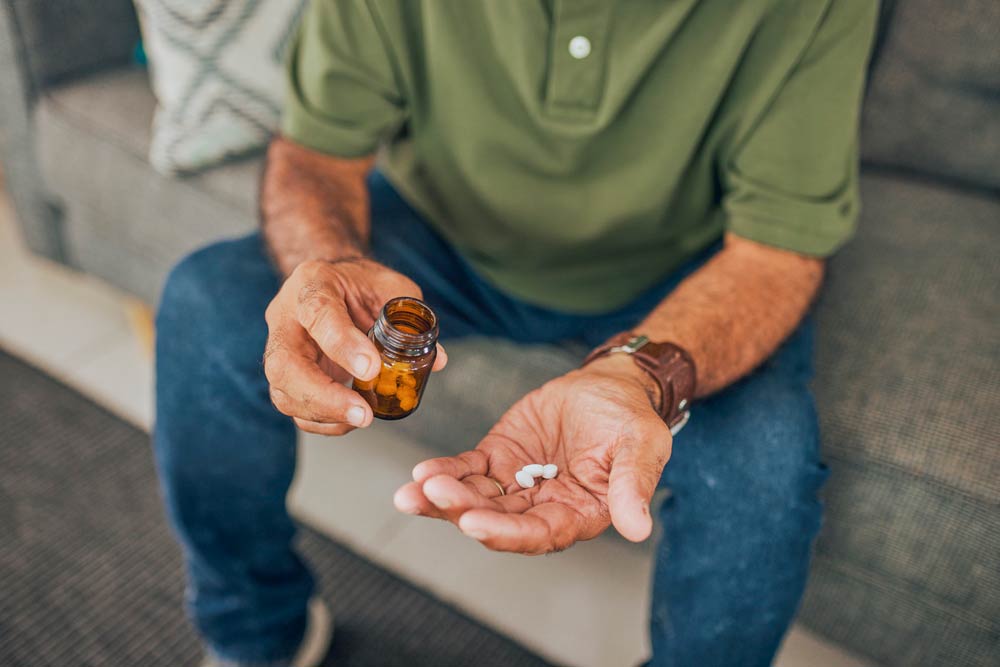Person holding medication bottle and tablets in hand, representing non-stimulant ADHD treatment options for adults.