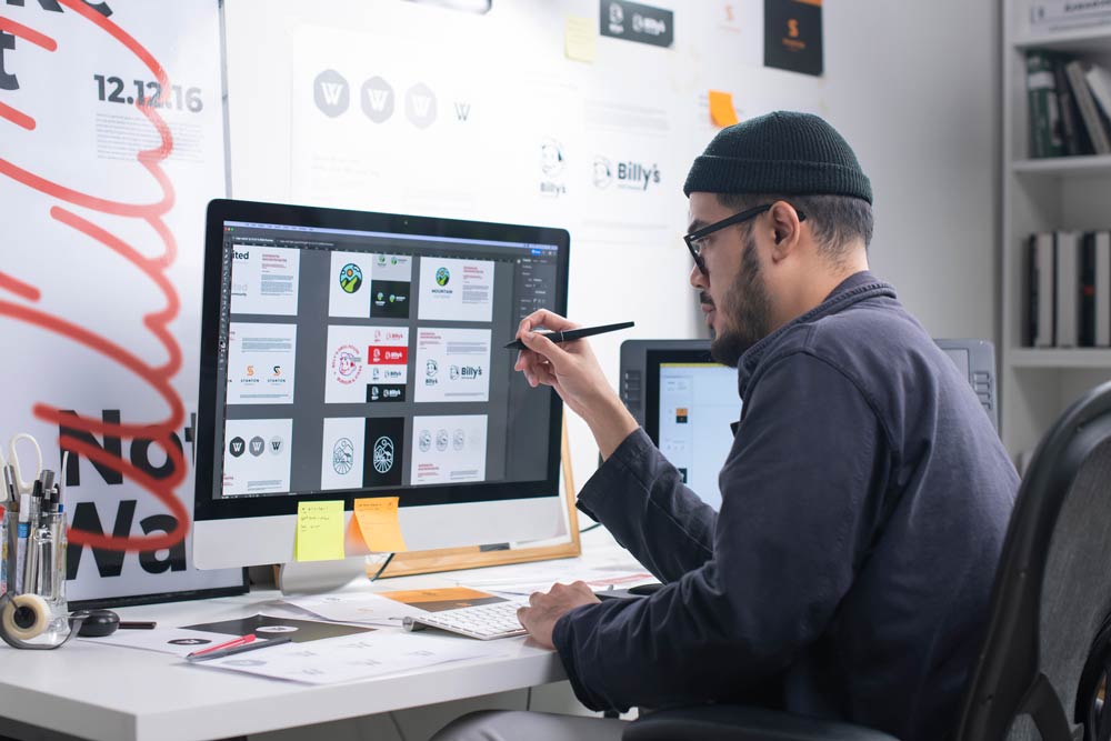 Man working on graphic design at a computer, representing ADHD-friendly careers that harness creativity and focus.