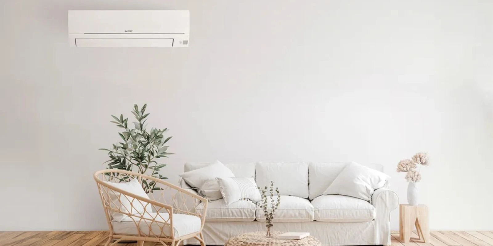 Climatisation réversible de la marque Mitsubishi sur un mur beige et canape cocooning