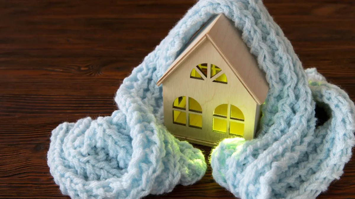 maisonnette en bois entourée d'une écharpe en laine illustrant une maison bien isolée