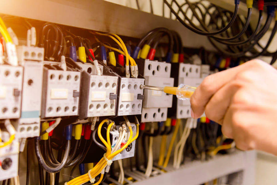 Technicien de maintenance qui vérifie un tableau électrique