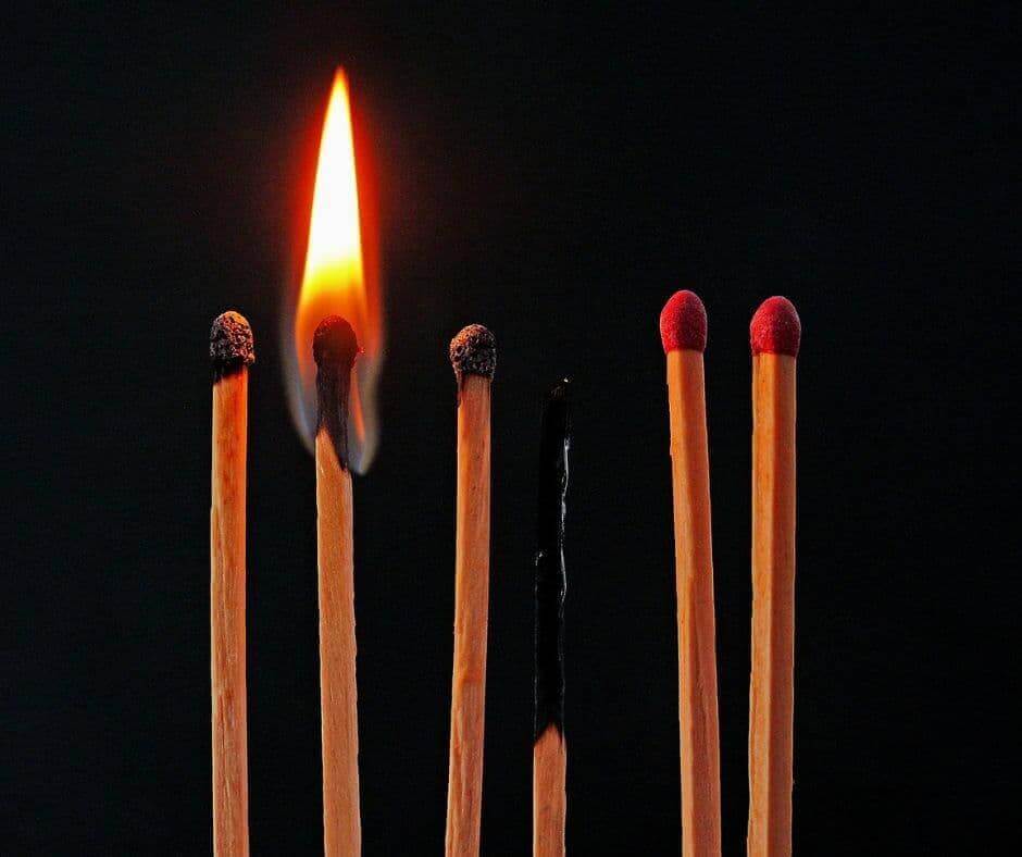 Brennende Streichhölzer, von denen nur eines noch brennt – Symbolbild für Burnout, emotionale Erschöpfung, Überlastung und die Hoffnung auf Regeneration.