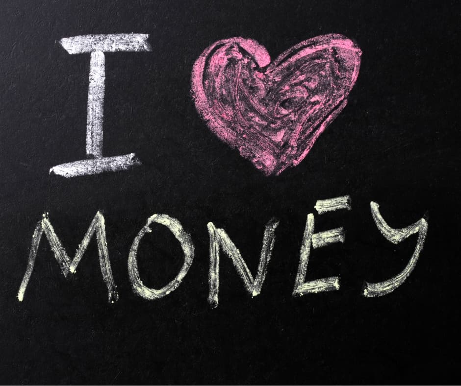 Handgeschriebener Schriftzug „I love money“ mit Herzsymbol auf schwarzem Hintergrund als Symbol für die emotionale Beziehung des Menschen zu Geld, Wohlstand und finanzieller Freiheit.