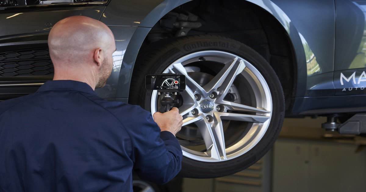 Service technician filming a vehicle inspection with a phone for video MPI documentation