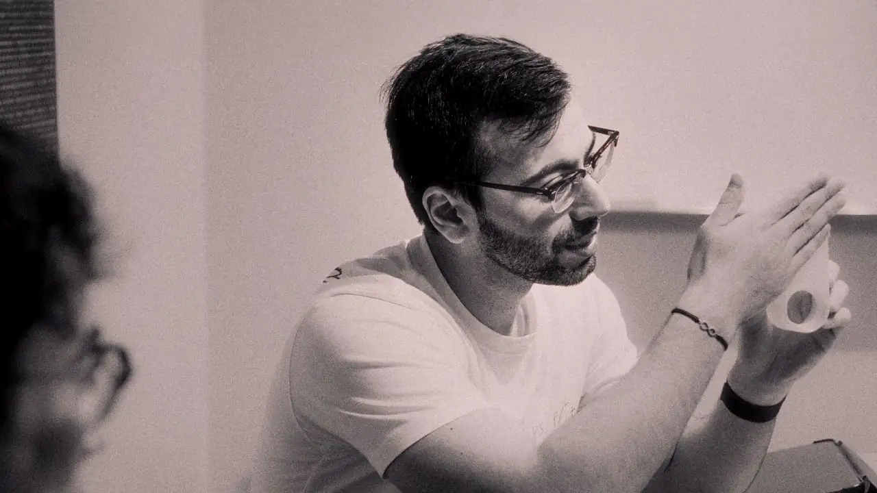 A man in glasses is holding a 3d printed mold while taking