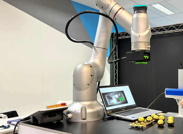 Leitor industrial acoplado em robô colaborativo para automação.