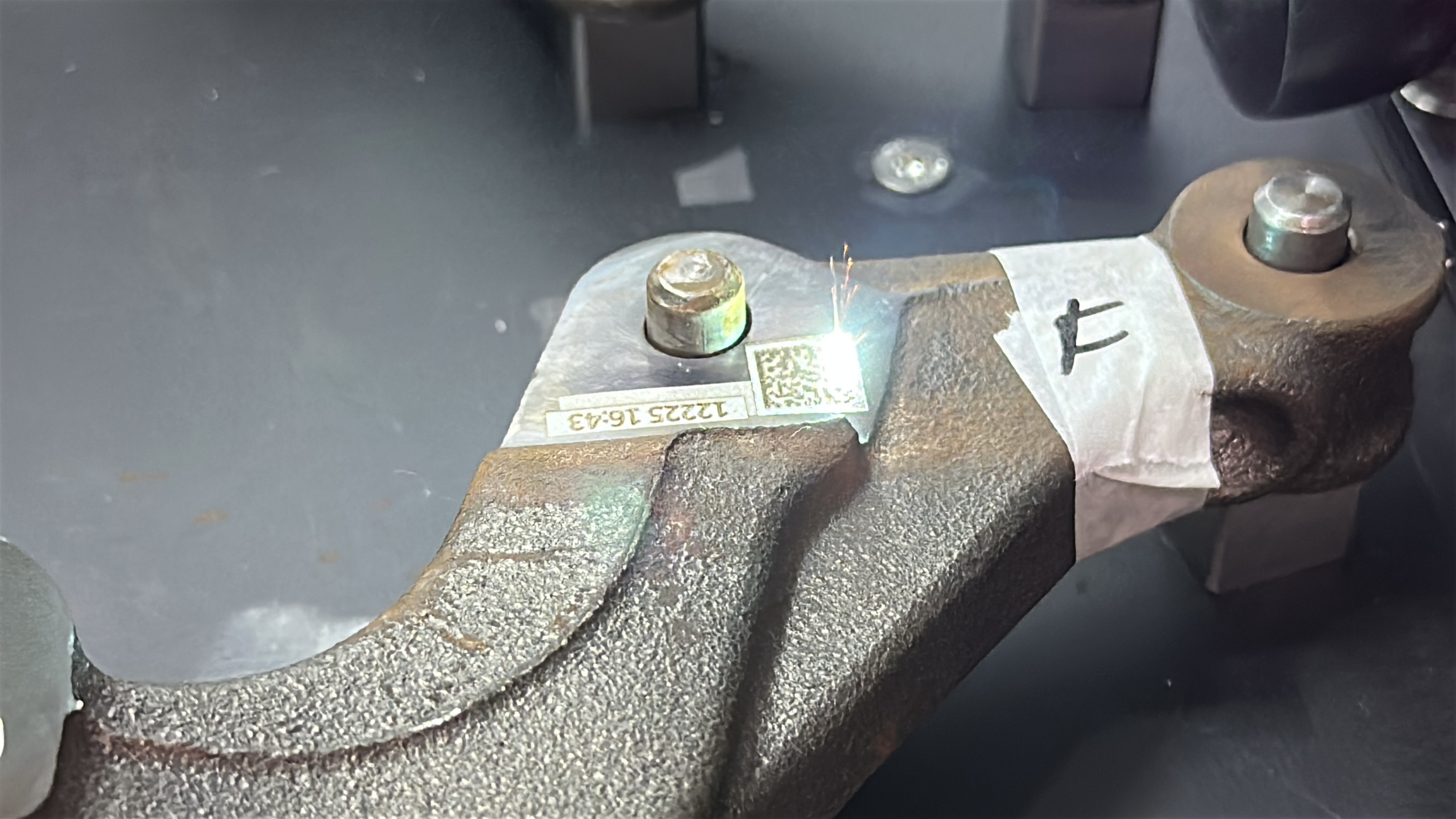 Código data matrix sendo gravado em peça automotiva de metal.