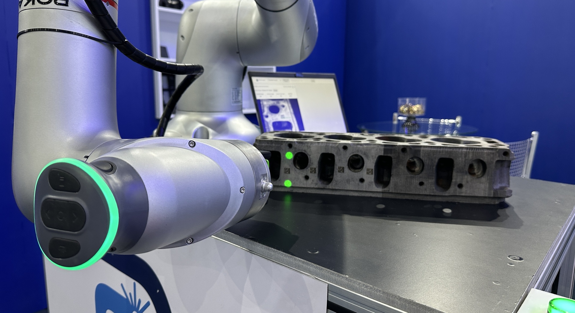 Sistema de visão industrial integrado em robô colaborativo realizando inspeção de códigos gravados em peça.