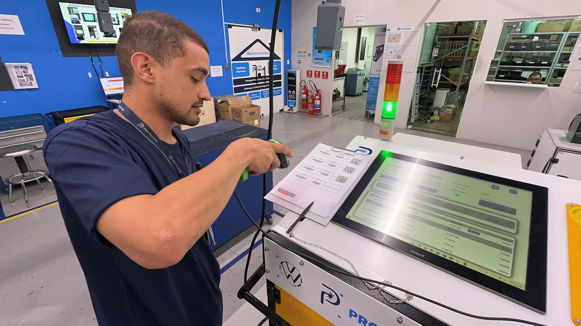 Operador realizando leitura de código com leitor de códigos industrial integrado em uma máquina de gravação a laser portátil.