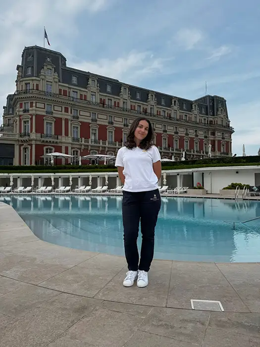 A student poses in front of her workplace, the Hôtel du Palais in Biarritz