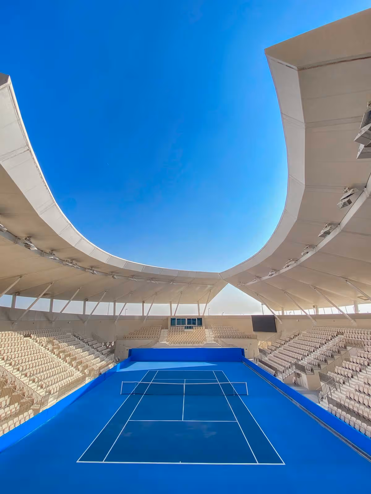 an image of the main court at Rafa Nadal Academy Kuwait with blue sky