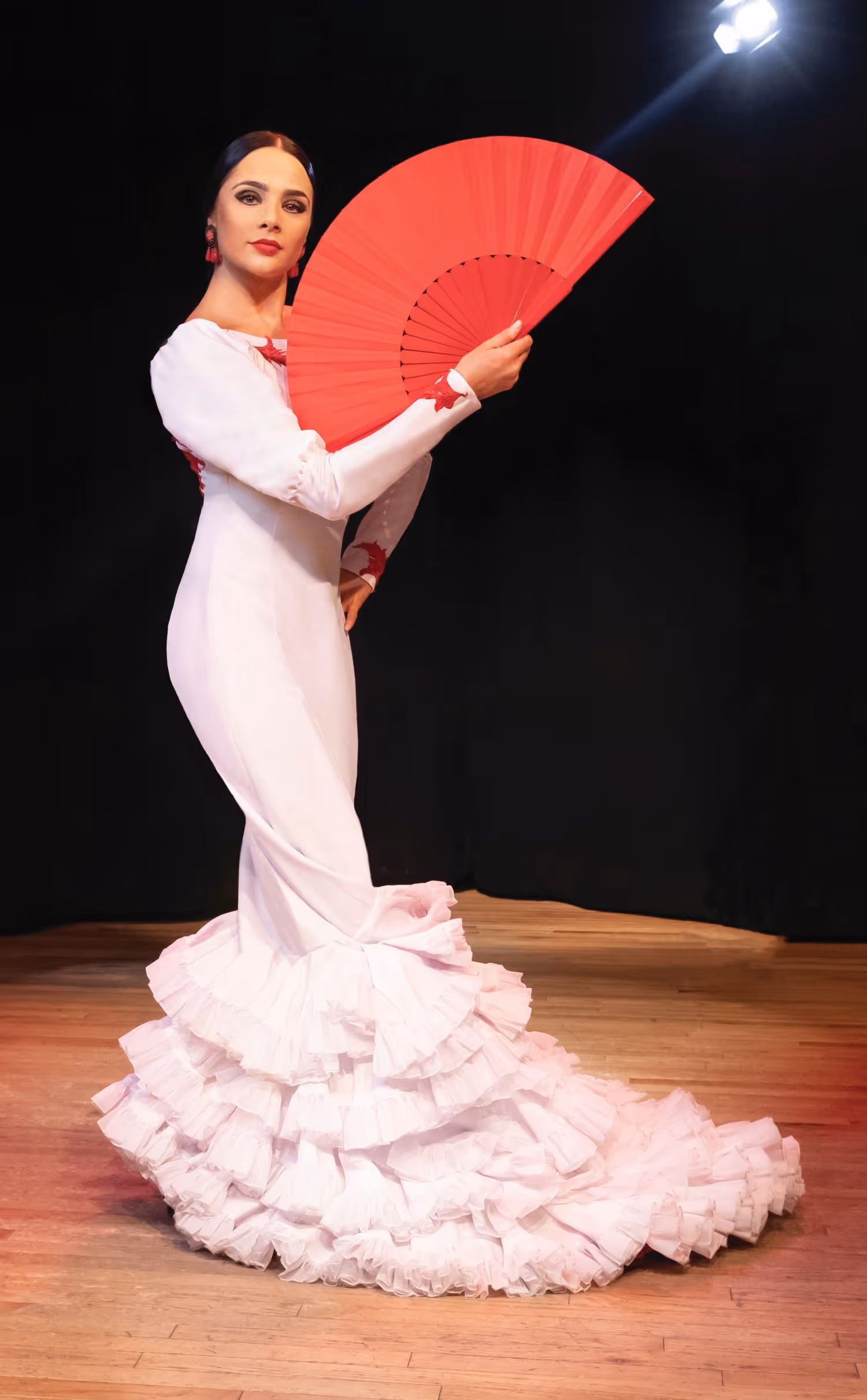 La Emi Flamenco dancer in white dress with red fan