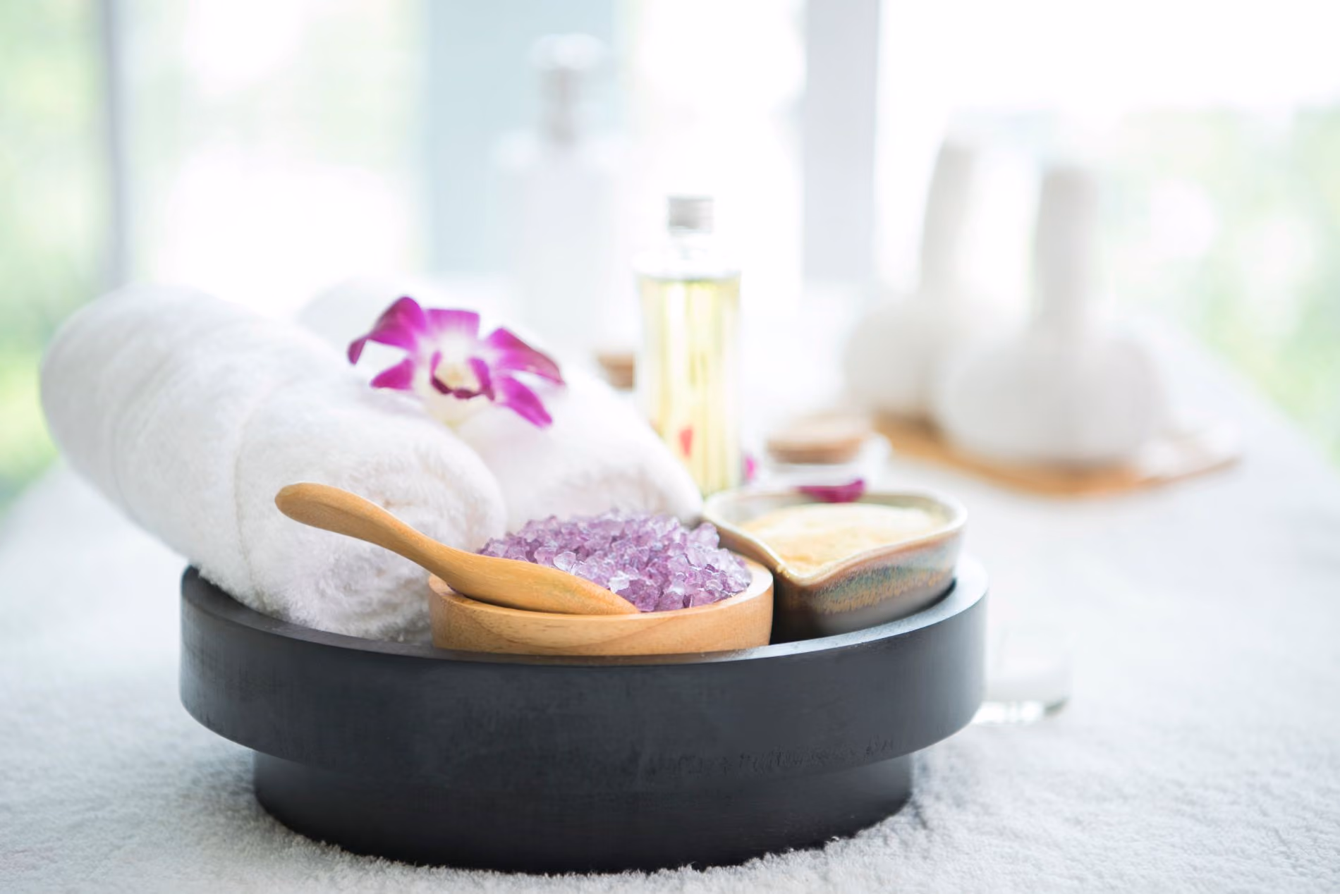 Various spa accoutrements purple salts oils and an orchid