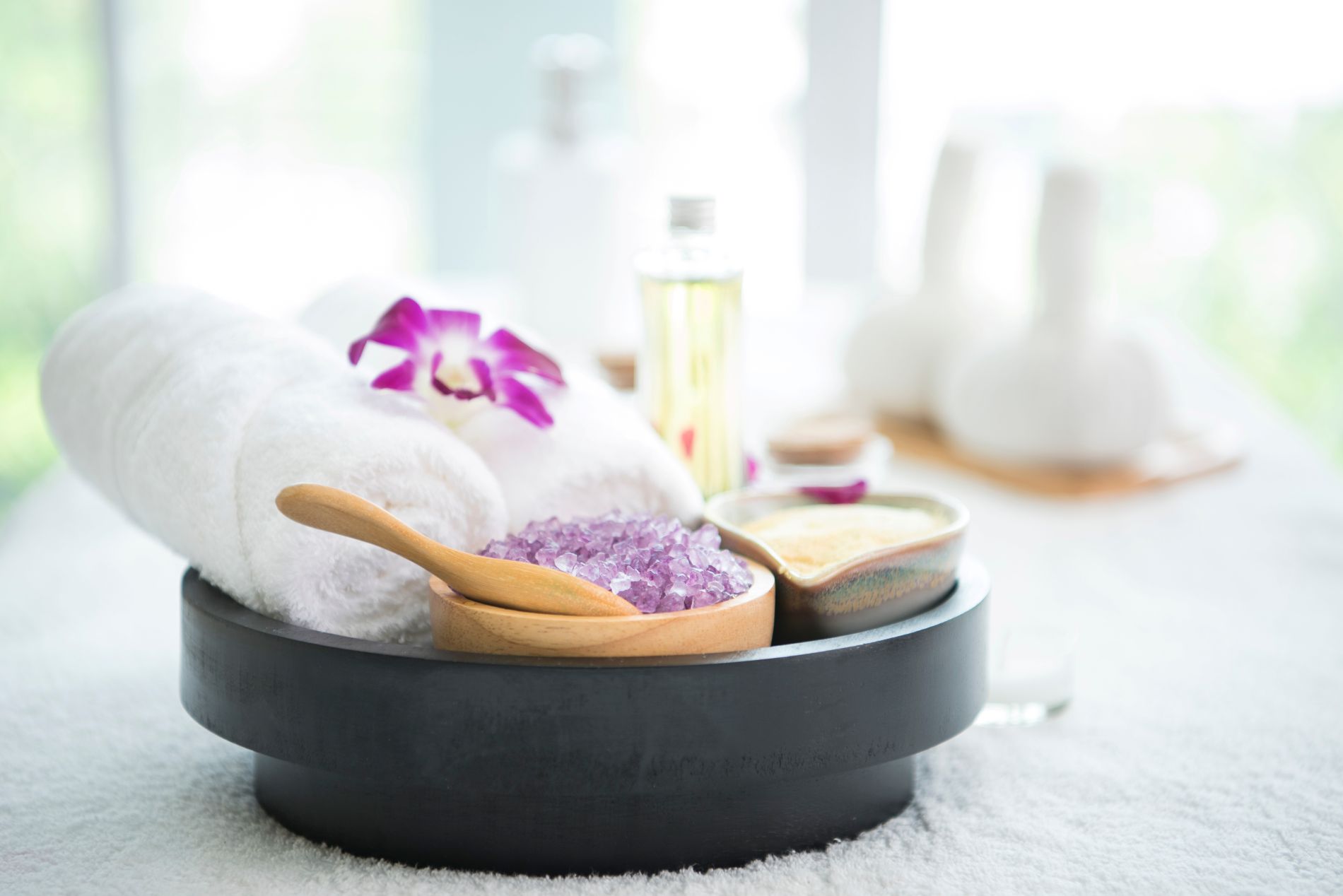 Various spa accoutrements purple salts oils and an orchid