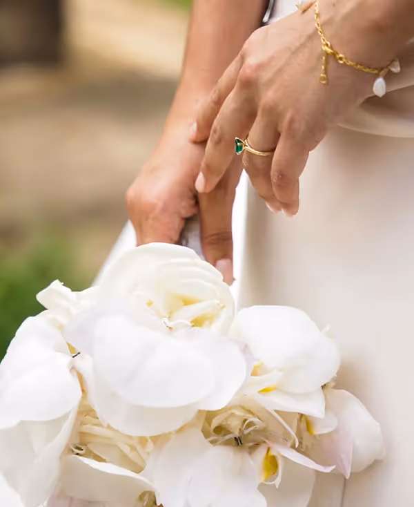 a person's hands touching a bouquet of white flowers