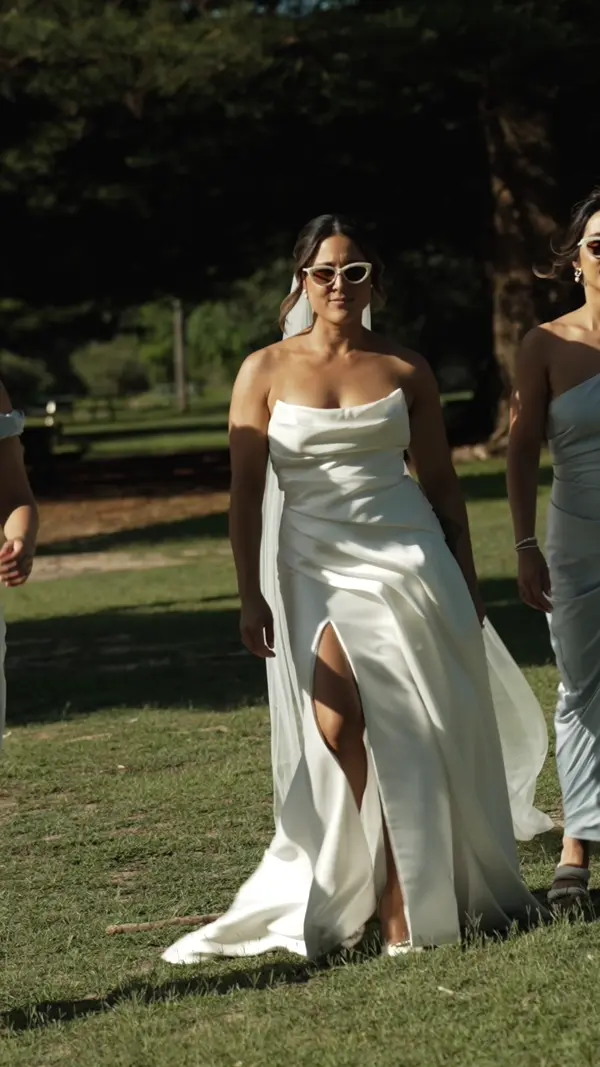 a woman in white dress walking on grass