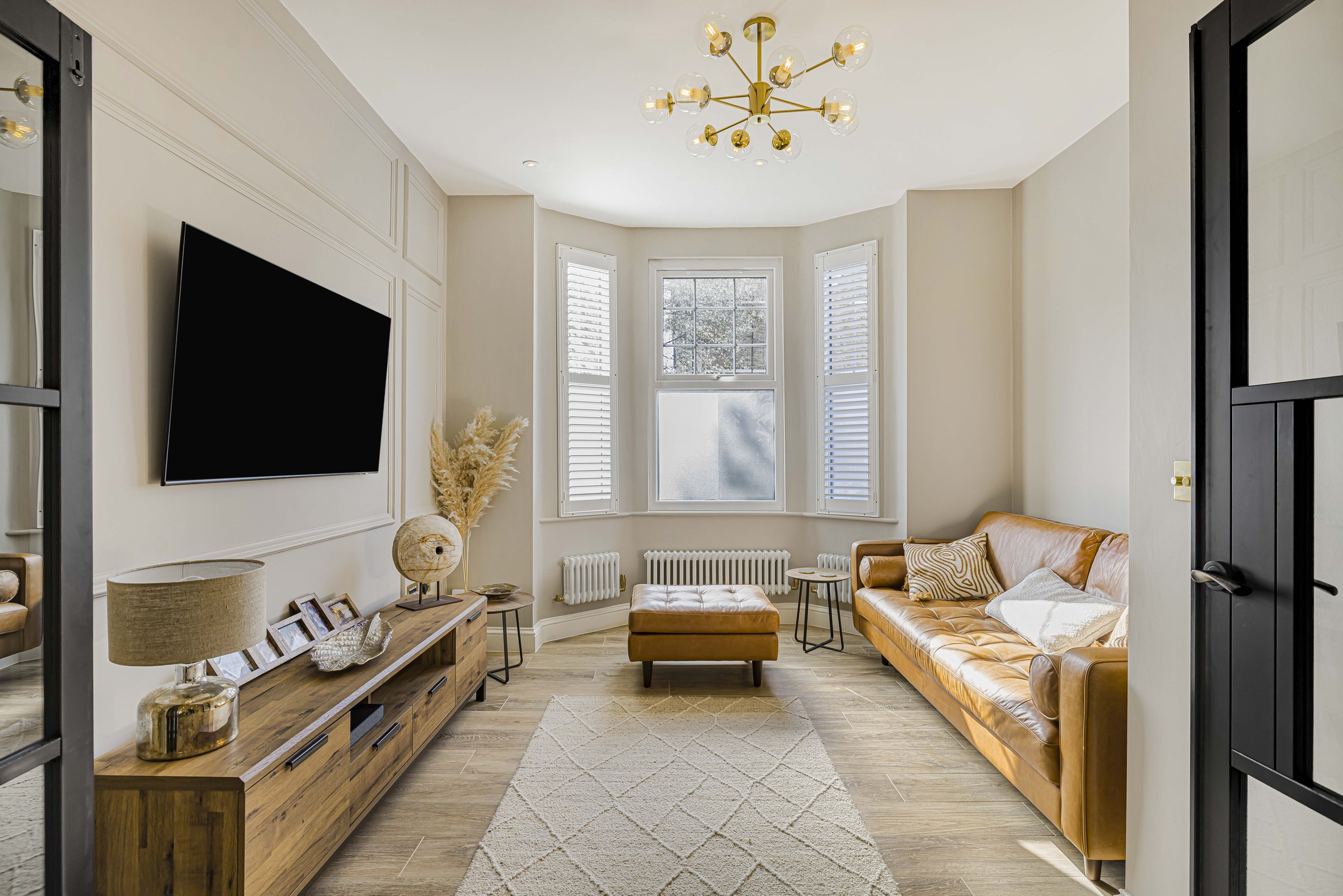 The front living room at Ravensbury Terrace, with the bay window and brass chandelier