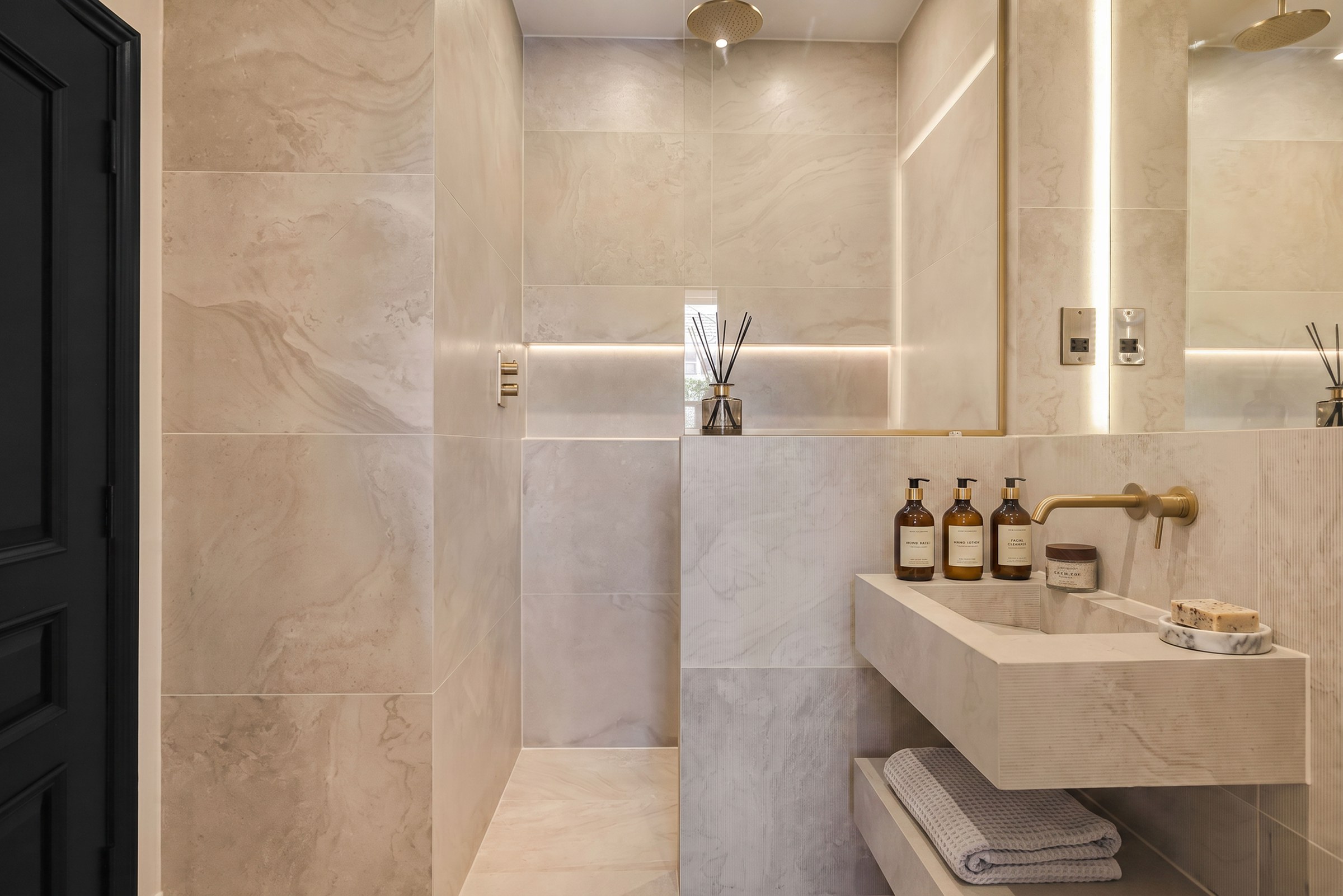The master bathroom at Abbeville Village, finished in stone with a walk-in shower