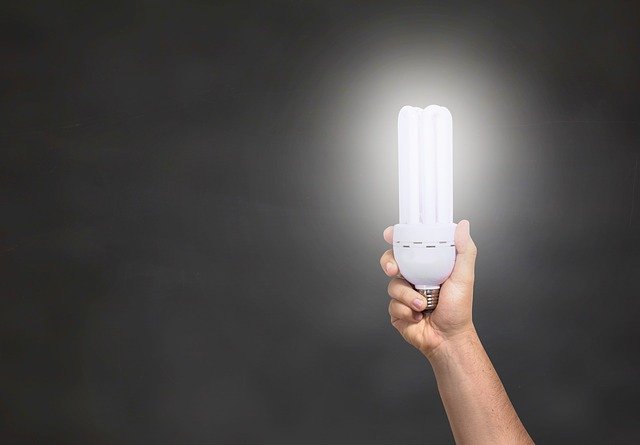 Hand holding a bright energy-efficient compact fluorescent light bulb