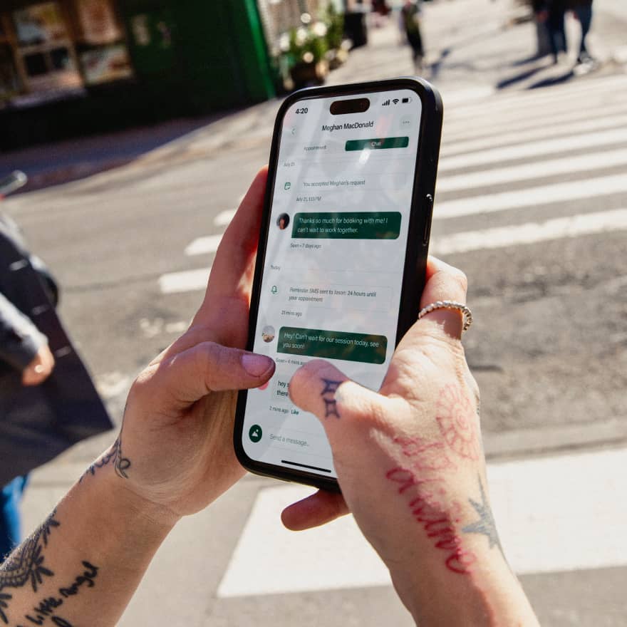 Hands holding a phone chatting with their clients on the Venue Ink app