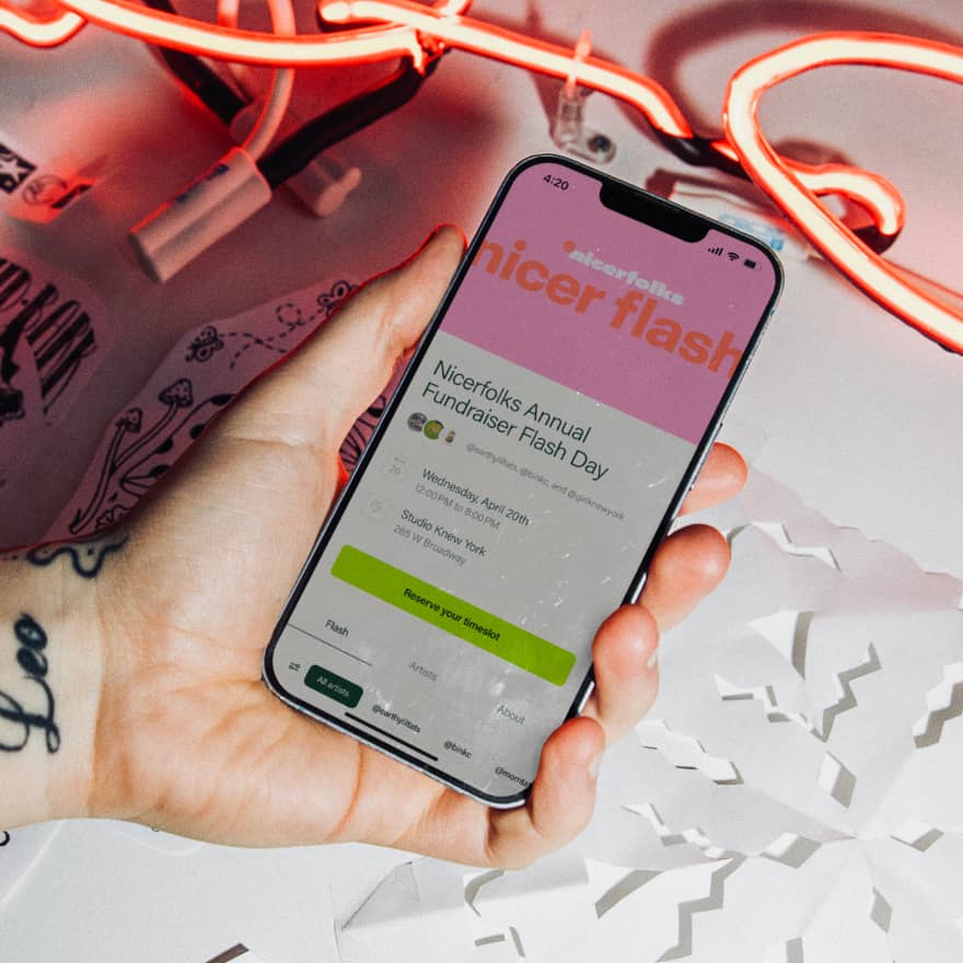 Hands holding a phone looking at a flash day event on Venue Ink