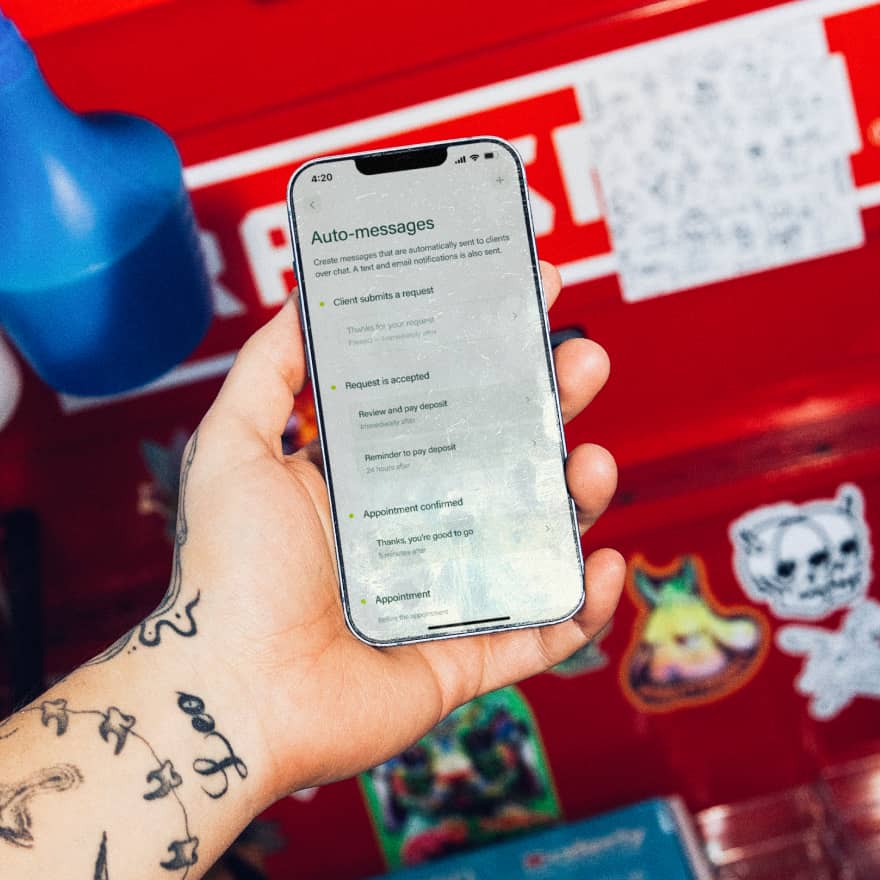 Hands holding a phone showing automatic reminders configured on Venue Ink