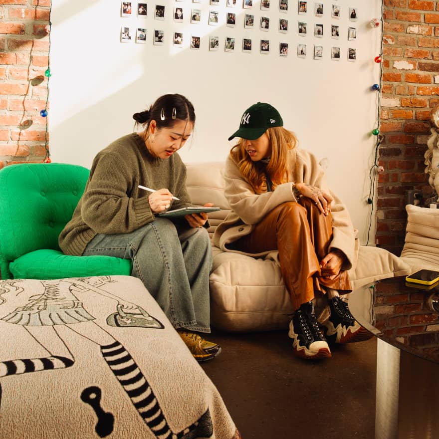 Two people sitting on a couch reviewing something on an iPad